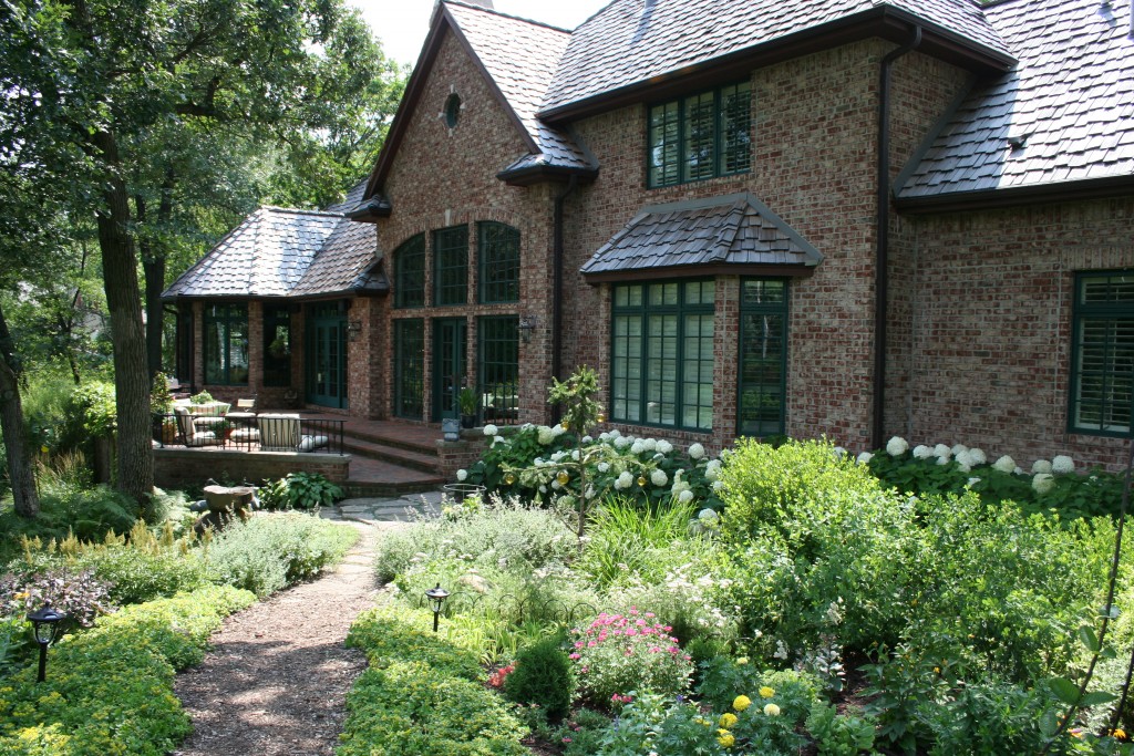While this large home in a Twin Cities suburb hardly qualifies as a cottage, the cottage garden sensibility is in this garden space.