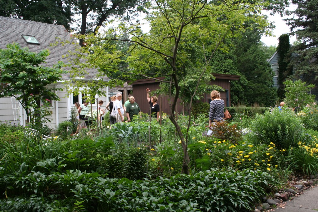 Tour goers check out a lush garden in front of a Minneapolis cottage. 