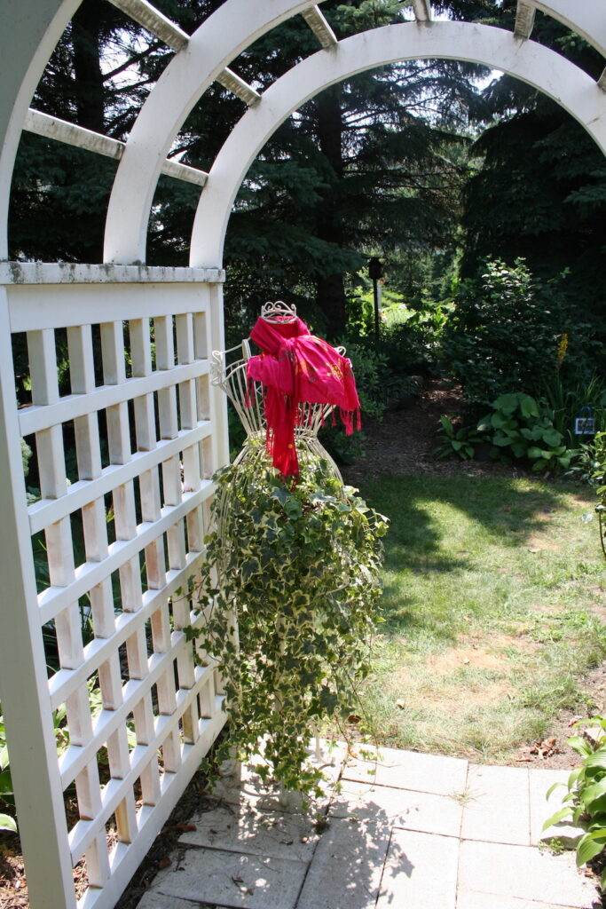 plant dangling from manequin wearing a scarf